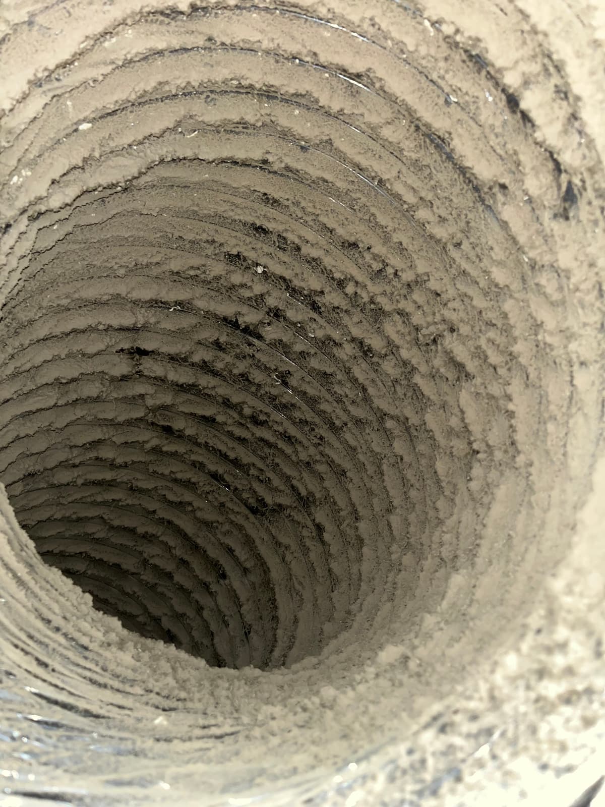 A bedroom branch duct run before cleaning, coated in debris