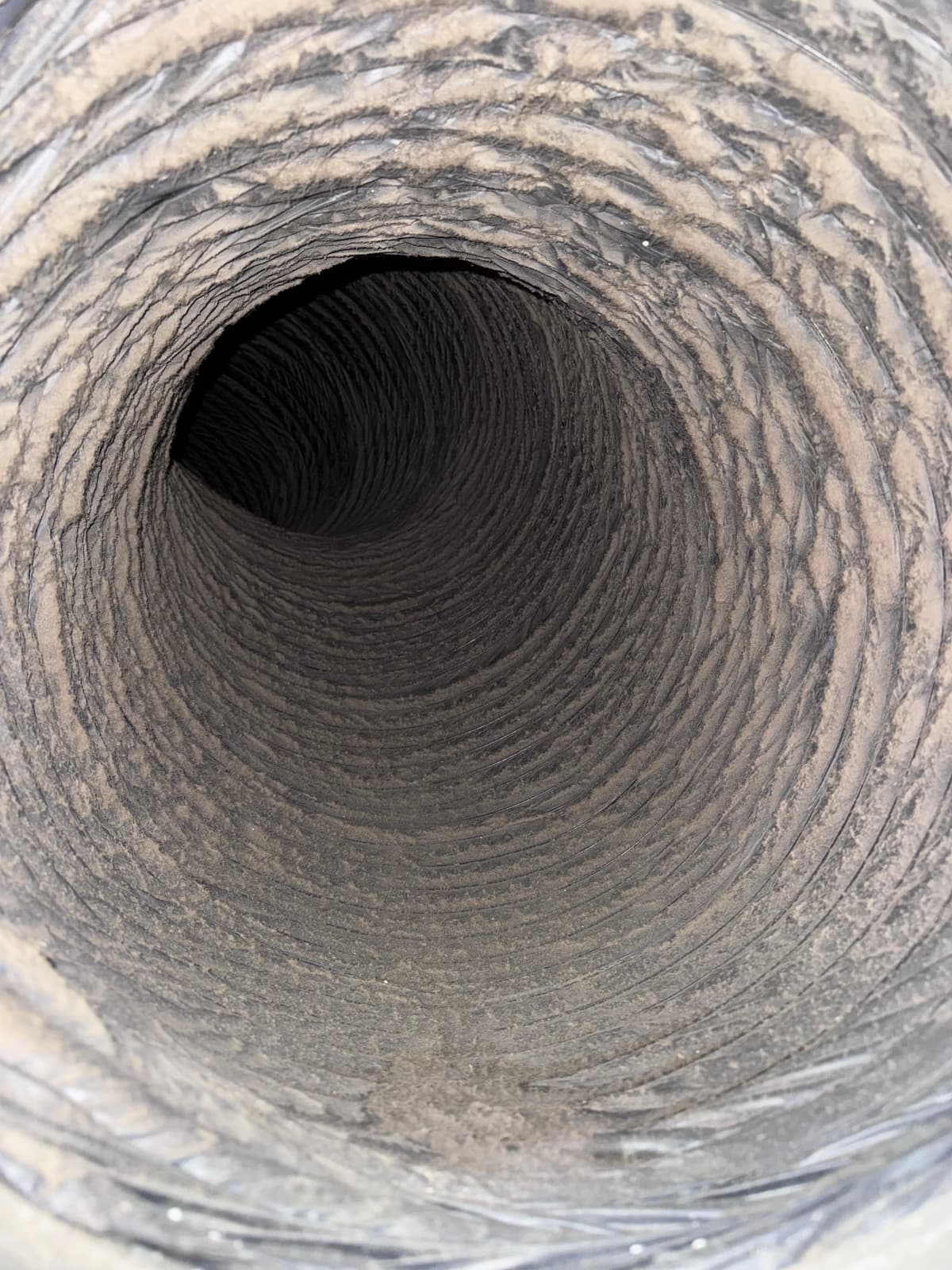 Dust built up inside a flexible supply duct before cleaning