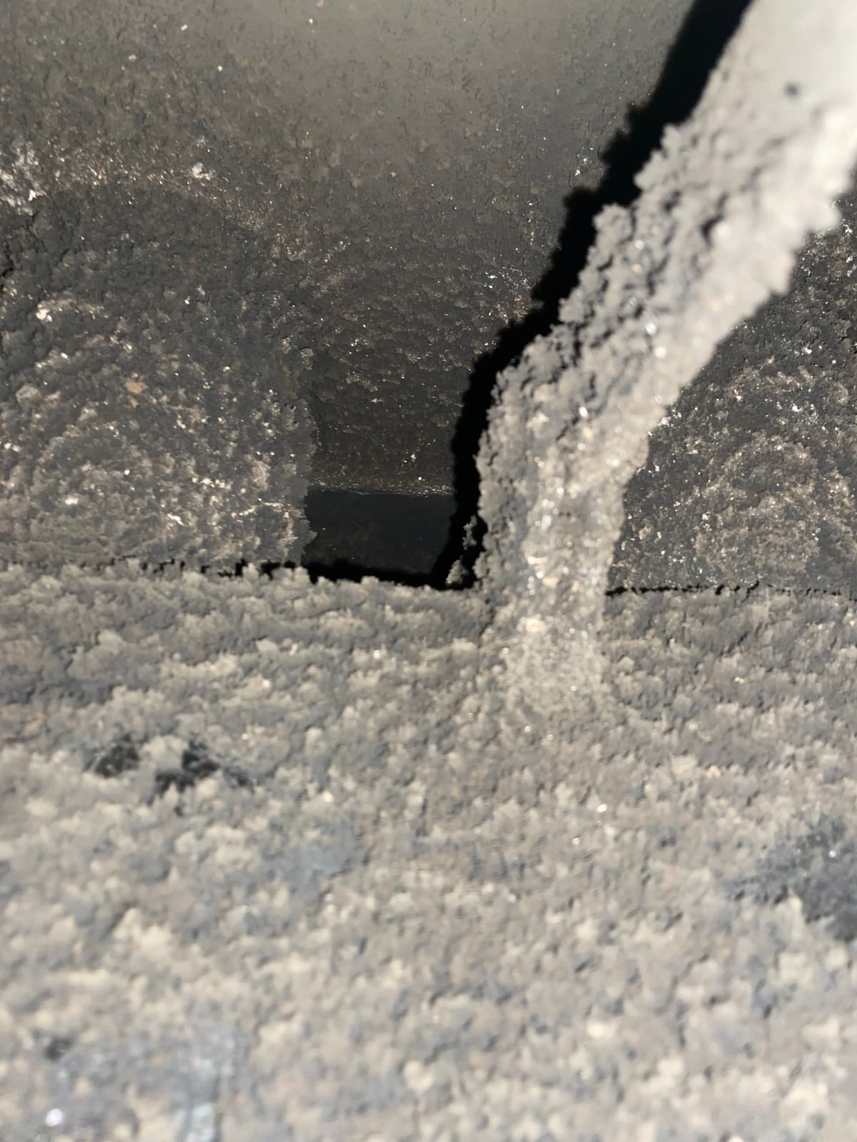 Creosote buildup on a fireplace damper before chimney cleaning