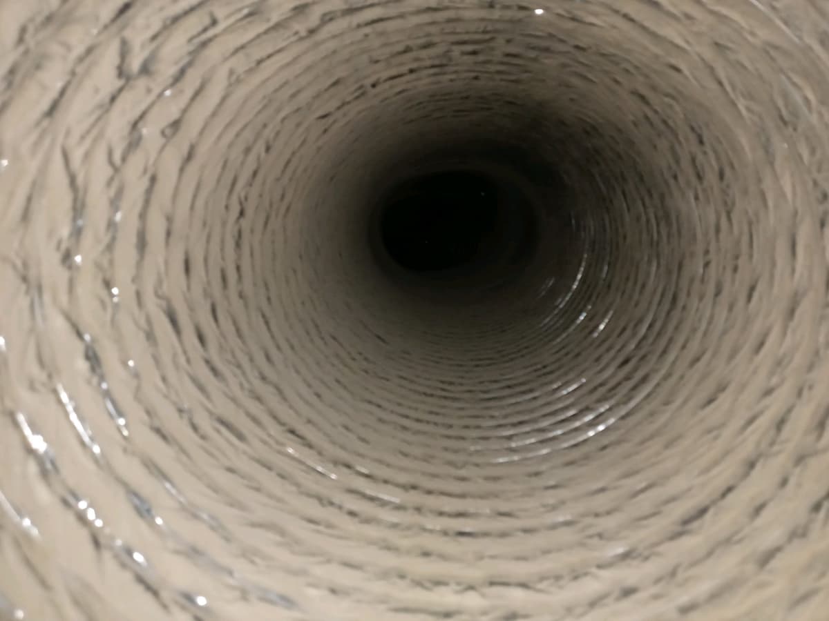 A flexible duct with a pale coating of dust before cleaning