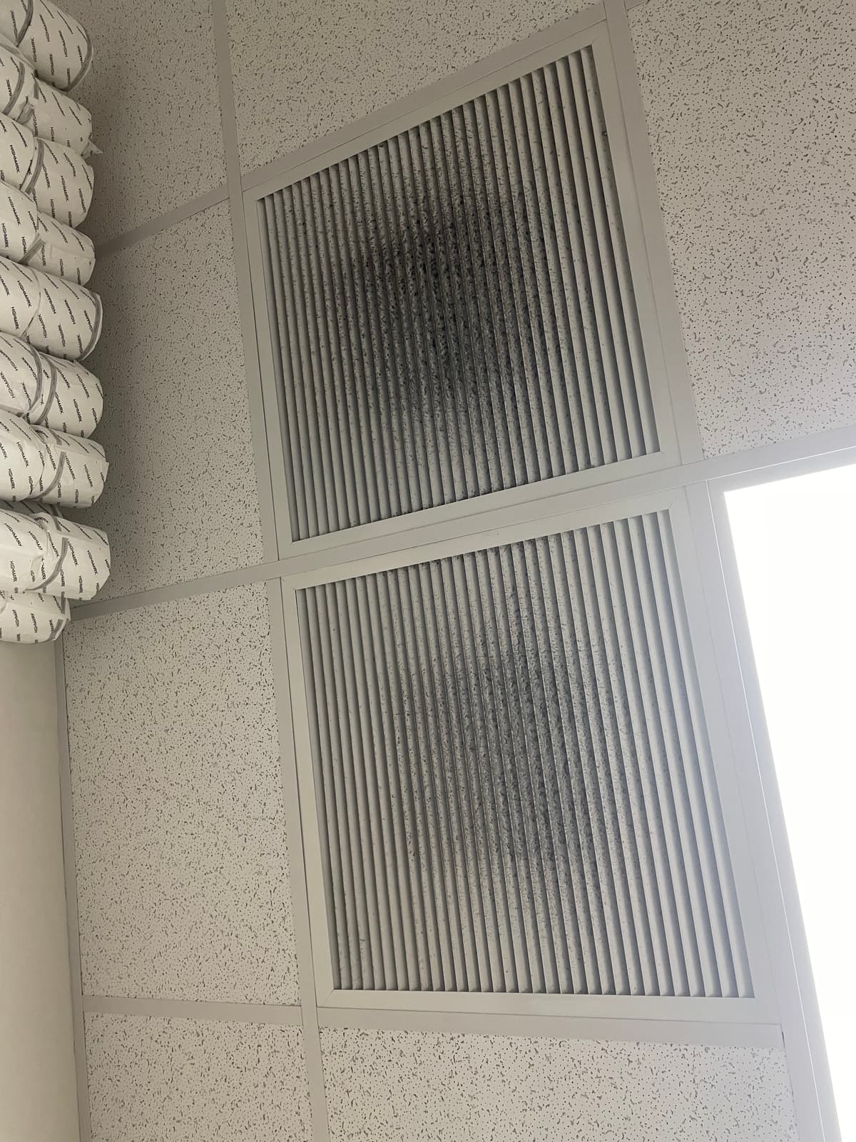 Dust-darkened commercial ceiling grilles before cleaning