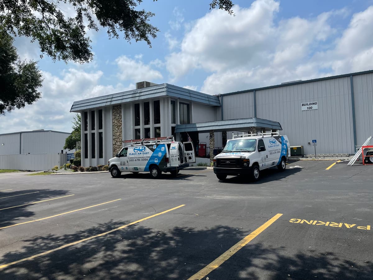 Clean Air Duct Cleaning vans outside an industrial building during a commercial duct cleaning