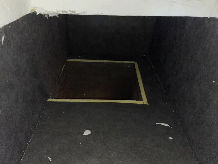 Inside a fibreglass-lined return plenum, the dark board surface where airborne dust settles first