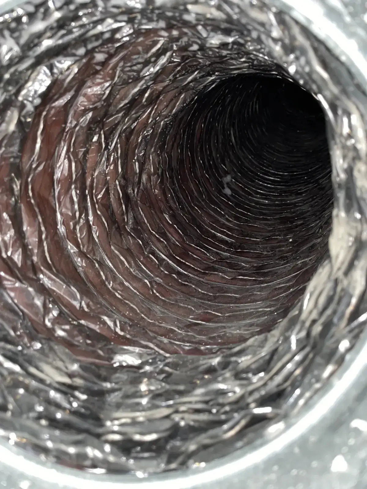 A flexible duct with brown dust through its length before cleaning