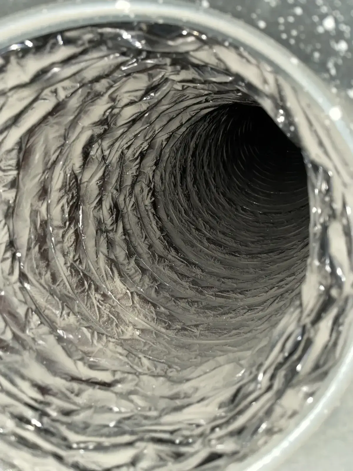 Heavy dust built up along the ribs of a flexible duct