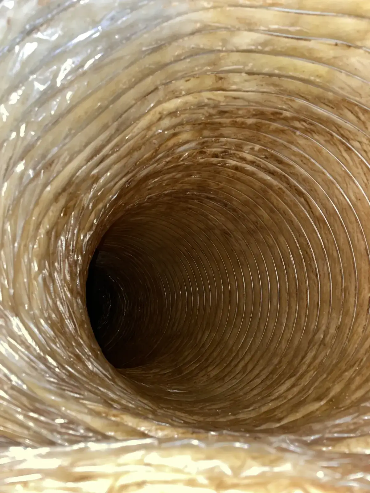 Dust inside a duct run lit from the register end