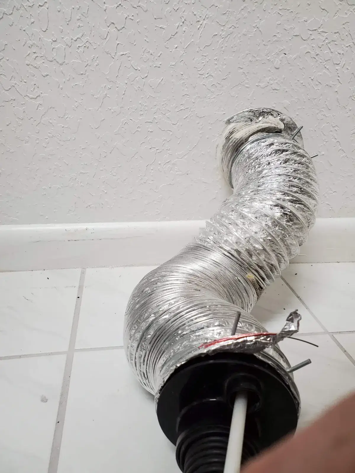A crushed dryer transition hose behind a dryer
