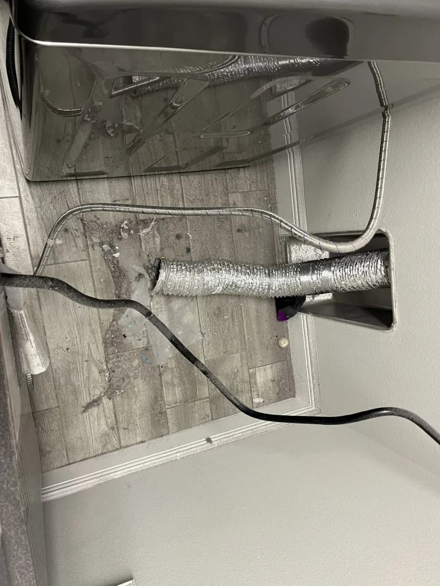 The flexible transition hose behind a dryer where it meets the wall duct, the first place lint collects