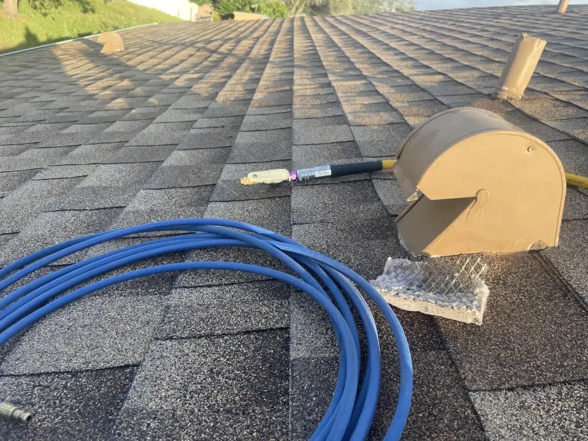 A blue air line coiled on a roof for a dryer vent cleaning