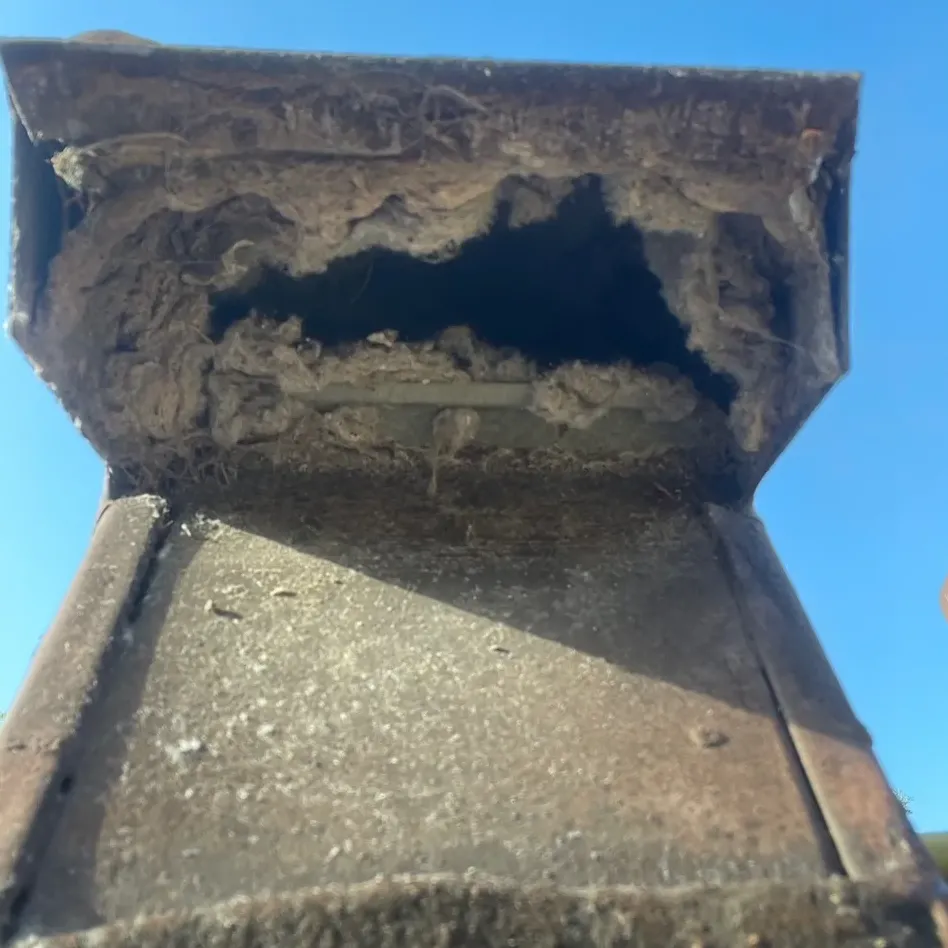 A roof dryer vent cap packed with lint before cleaning
