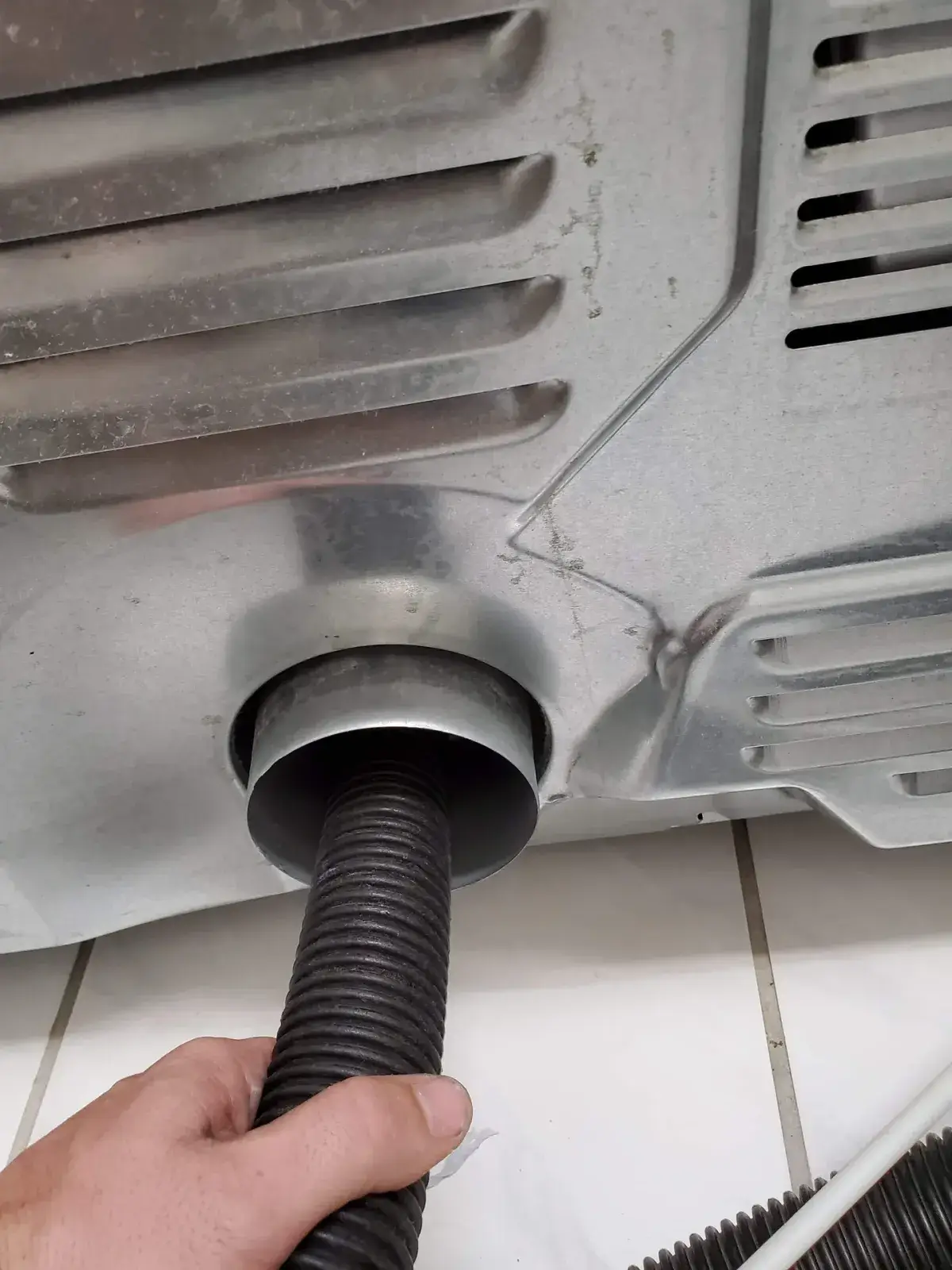 The flexible transition hose behind a dryer at the wall connection