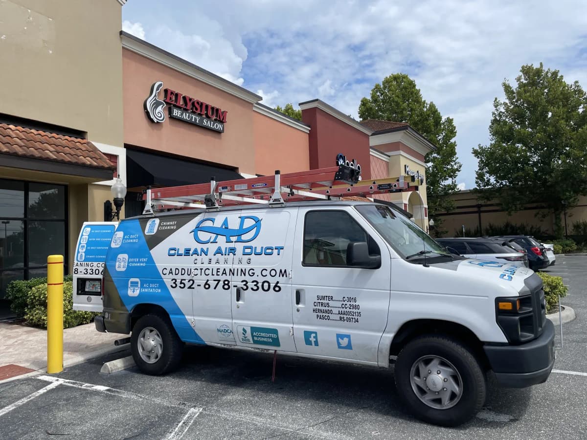 A Clean Air Duct Cleaning van parked outside a Florida salon unit, on site for an HVAC system clean
