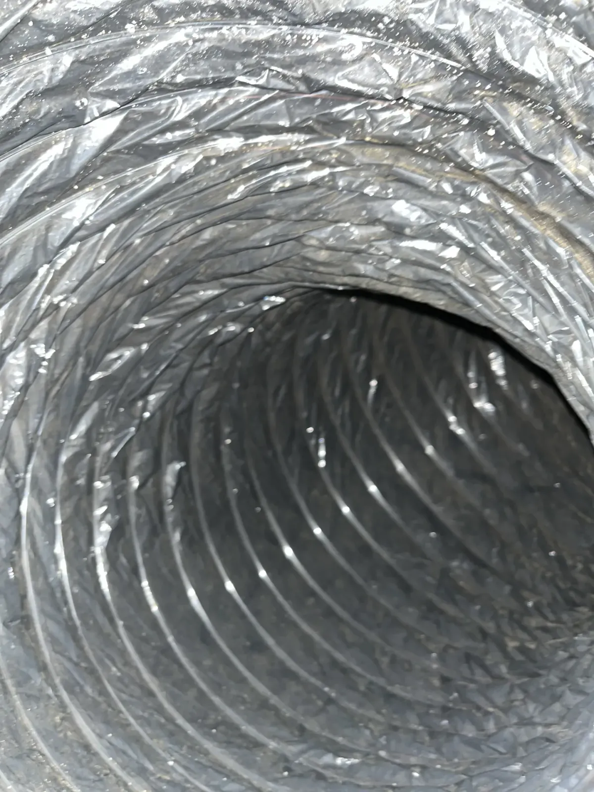 The same style of flexible duct after source-removal cleaning, back to a bare foil surface