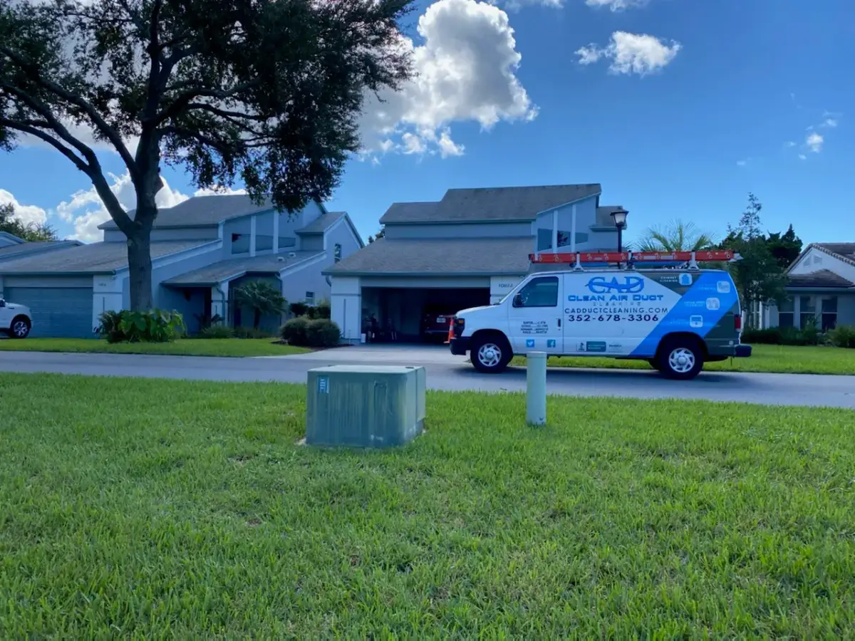 A Clean Air Duct Cleaning van seen across the front lawn of a home