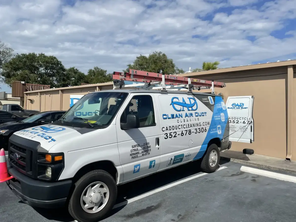 Two Clean Air Duct Cleaning vans parked outside a commercial building