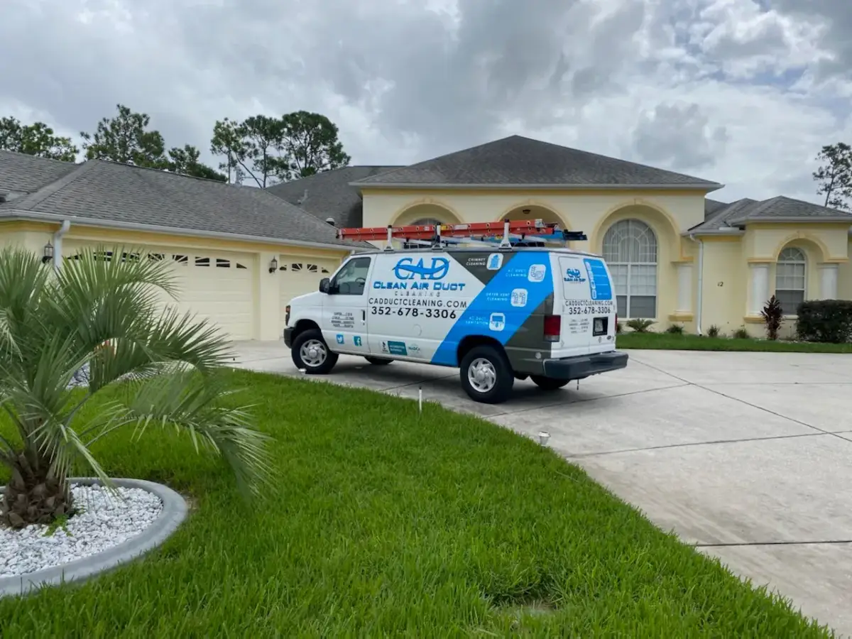 A Clean Air Duct Cleaning van outside a home with palms and a tidy front garden