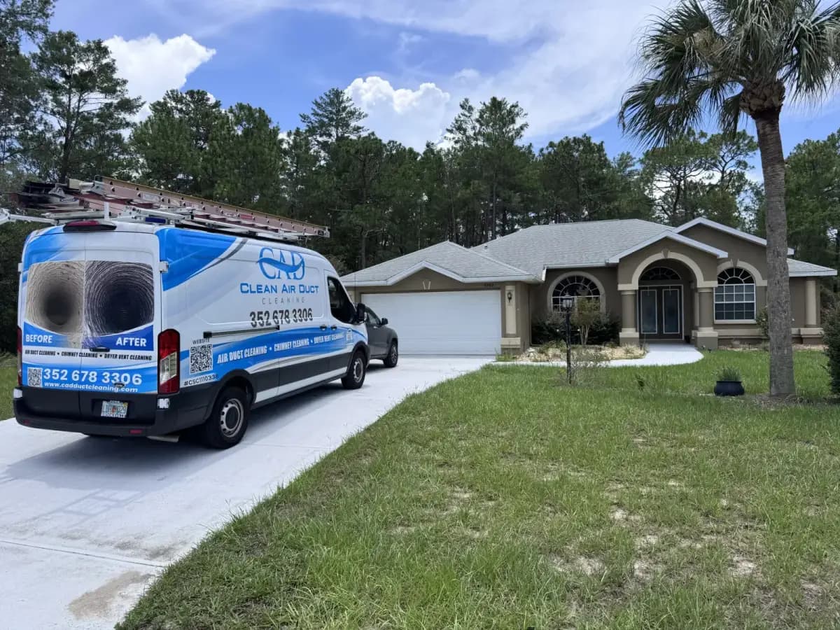 A Clean Air Duct Cleaning van in front of a single-story ranch home