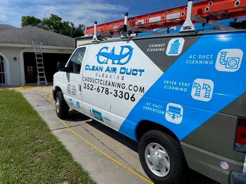 The side of a Clean Air Duct Cleaning van listing chimney, AC duct and dryer vent cleaning