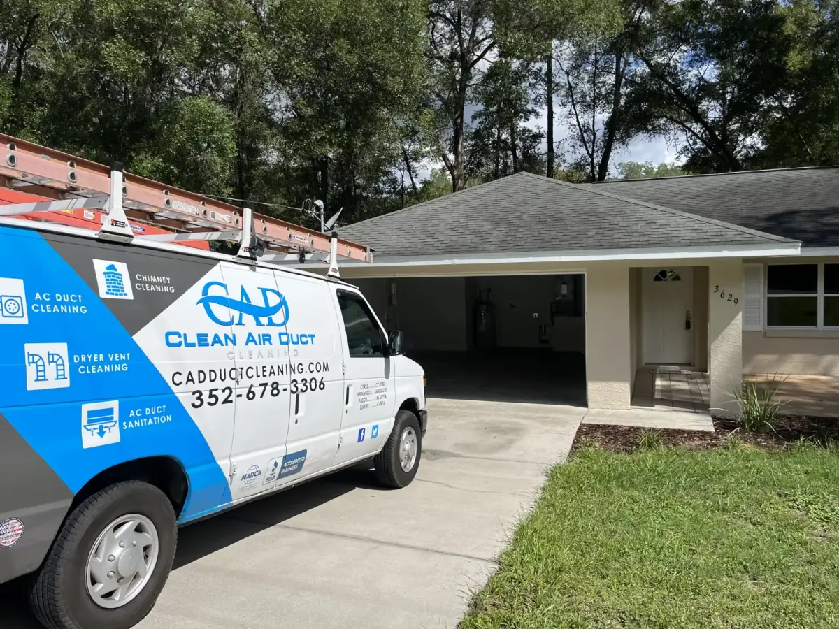 A Clean Air Duct Cleaning van outside a single-story home with a carport