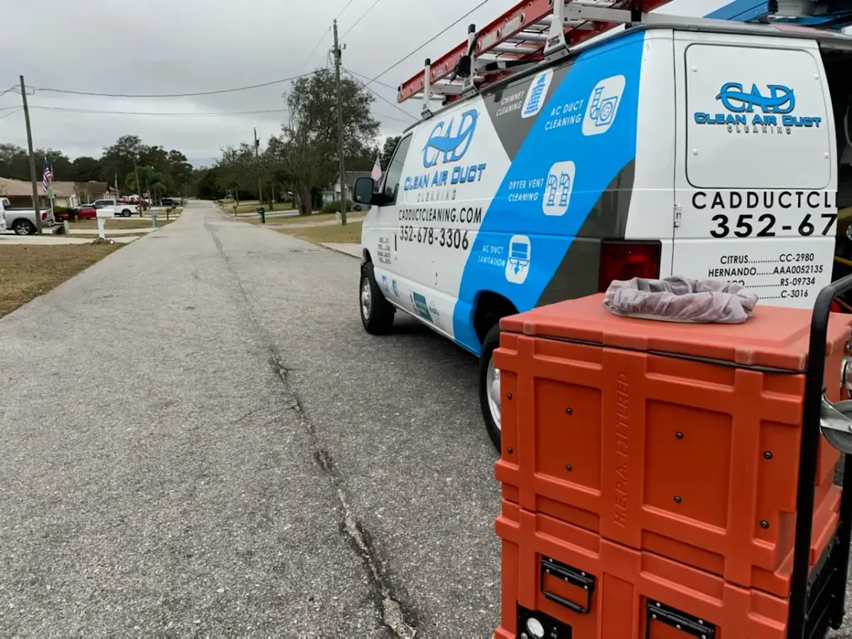 A Clean Air Duct Cleaning van parked at a corner in a residential neighborhood