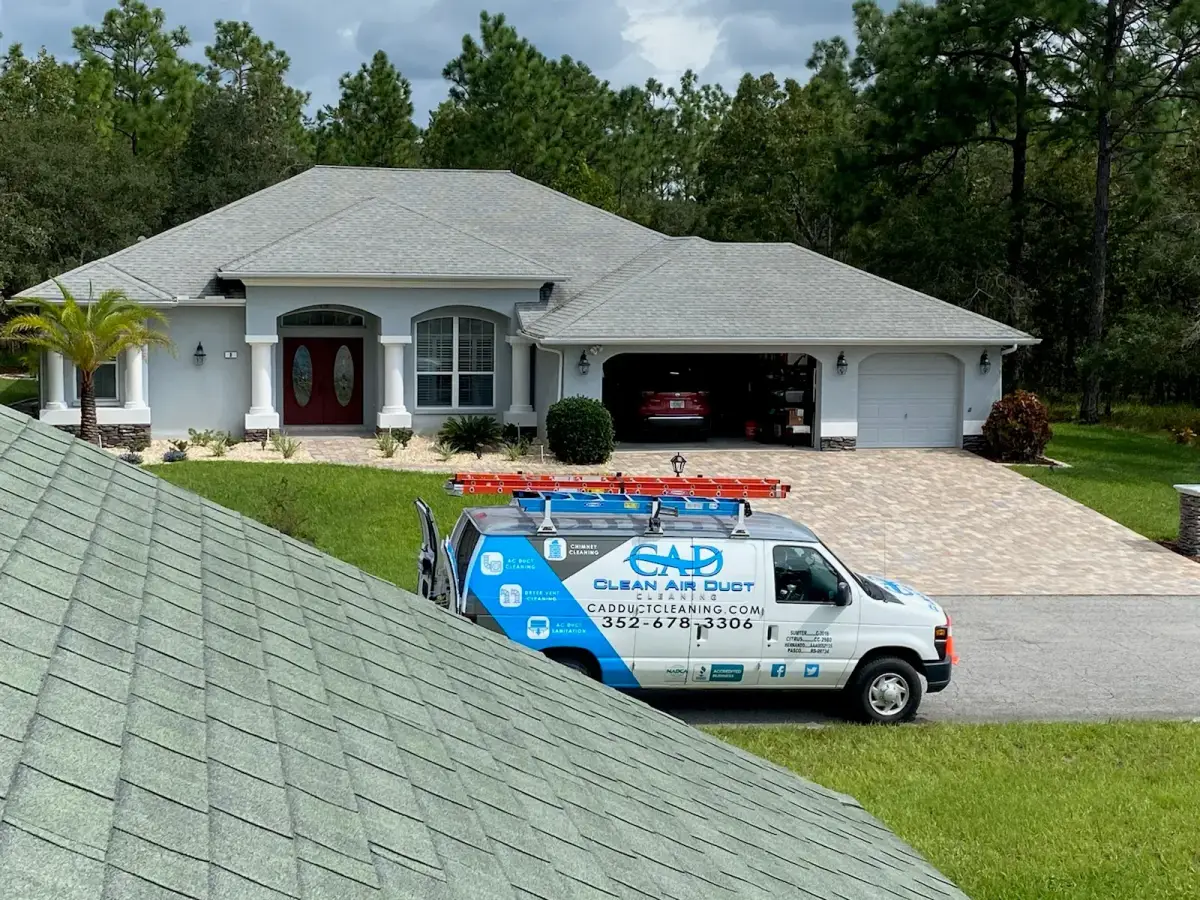 A Clean Air Duct Cleaning van outside a home with a tile roof and arched entry