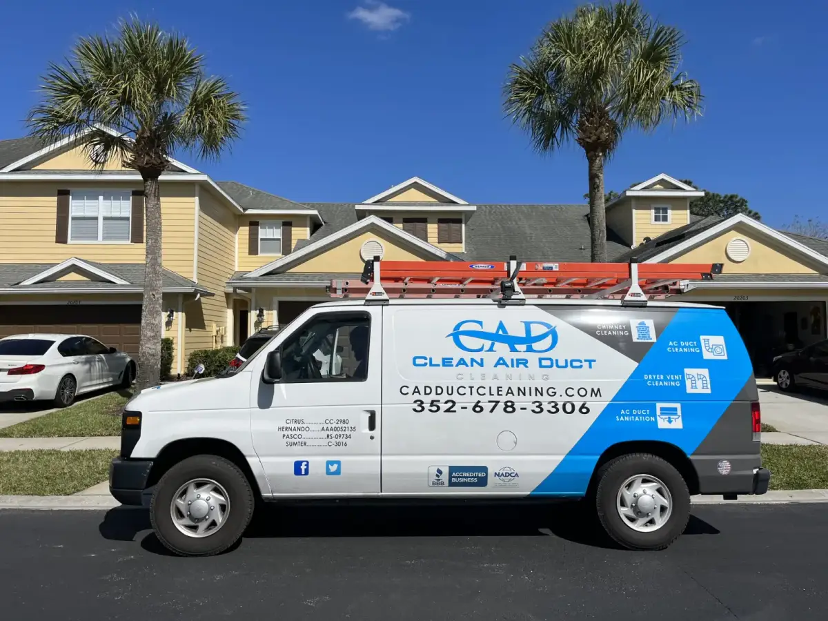 A Clean Air Duct Cleaning van parked outside a row of townhomes