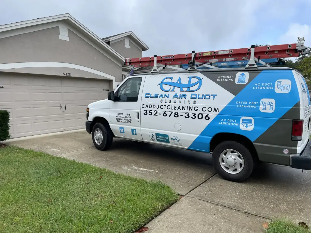 A Clean Air Duct Cleaning van parked on the street outside a two-story home