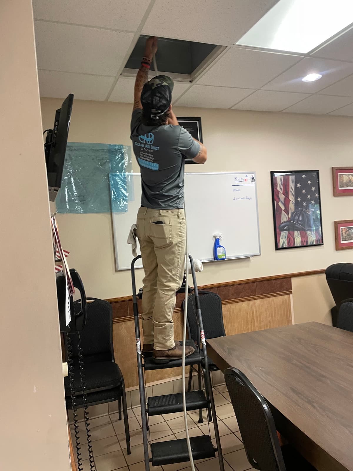 A Clean Air Duct Cleaning technician servicing ceiling vents in a Central Florida office