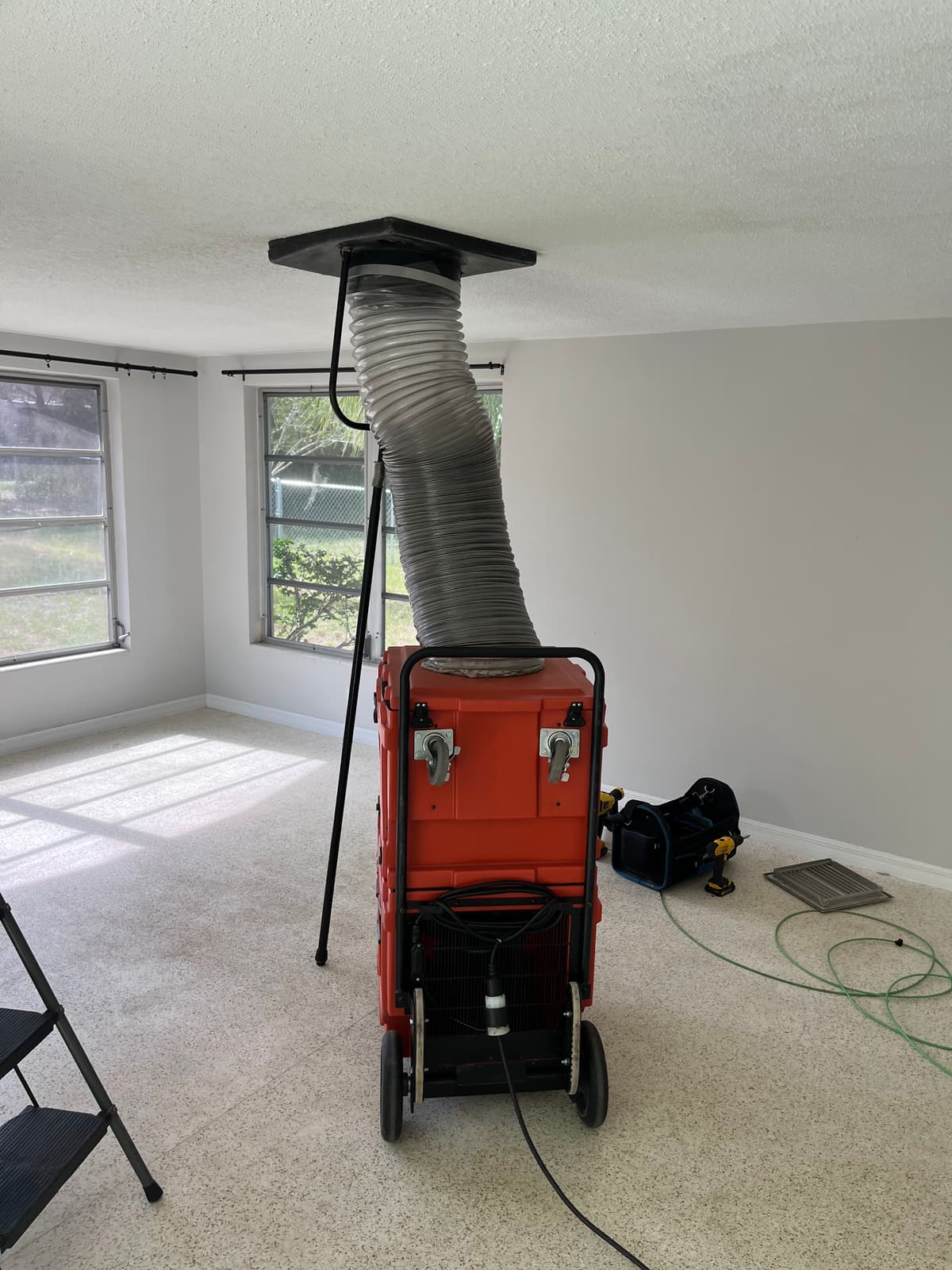 A negative-air machine connected to the duct system, putting the whole system under vacuum during cleaning