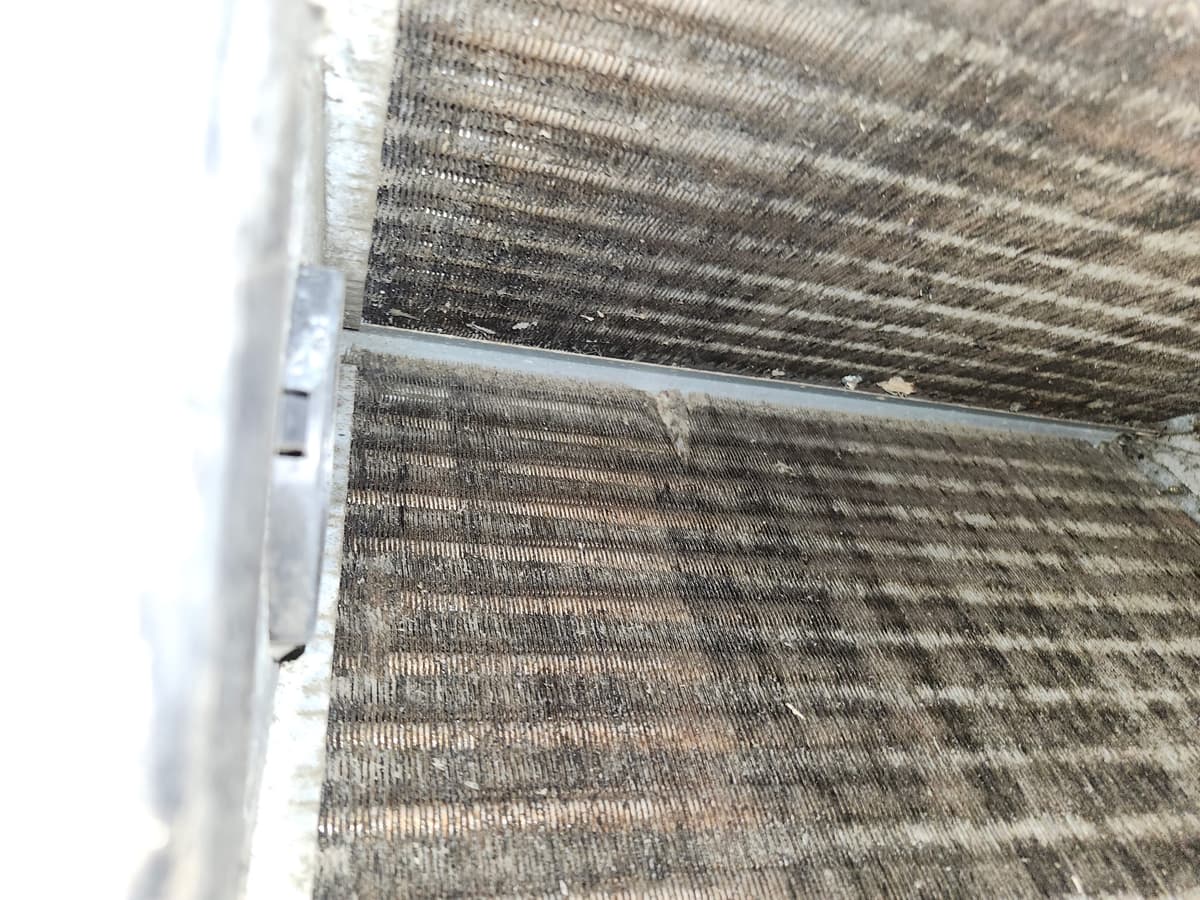 An evaporator coil with dust and debris packed between the fins