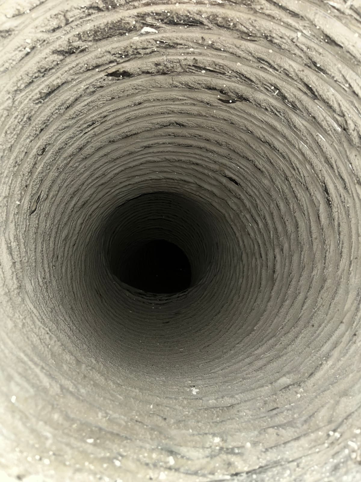 A flexible duct coated in gray dust before cleaning