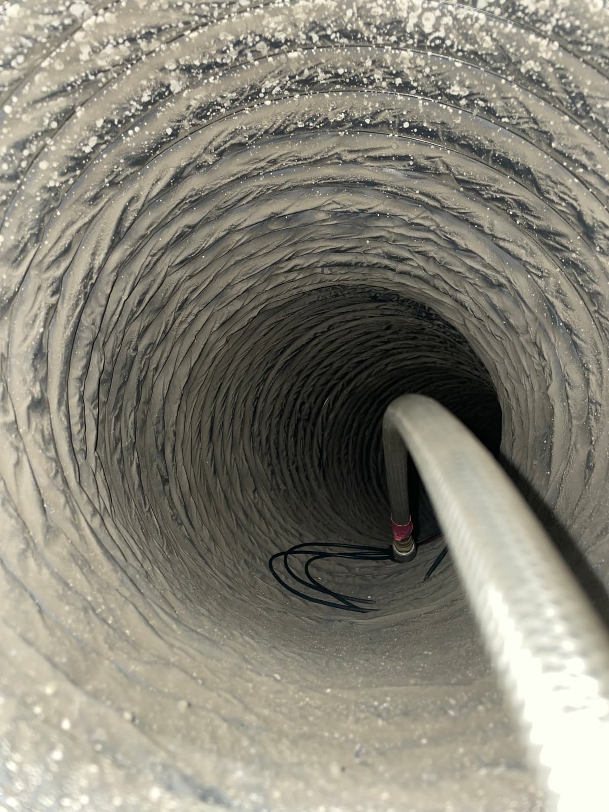 An air-powered cleaning whip working inside a flexible duct