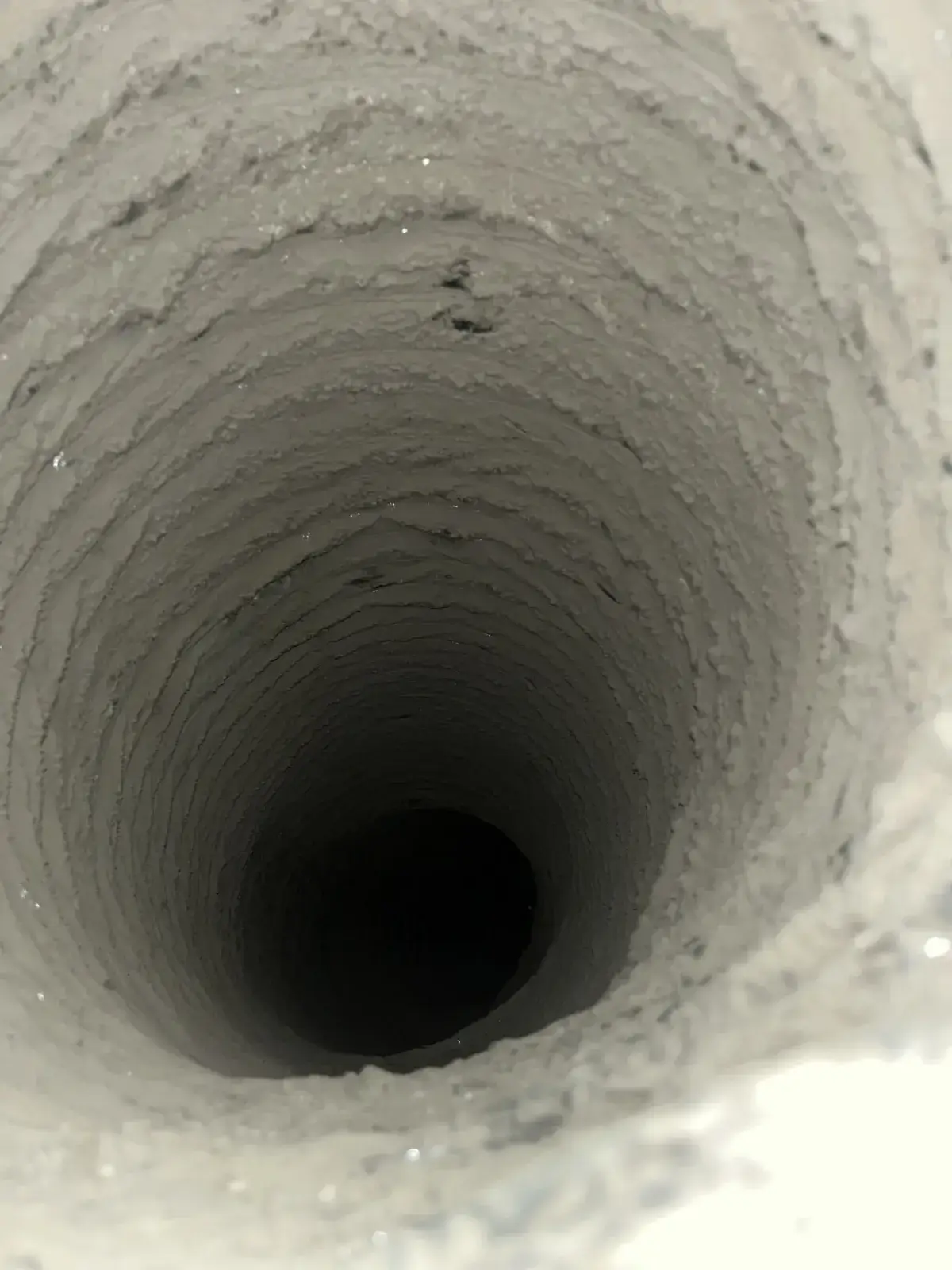 Pale dust lining a duct run before cleaning