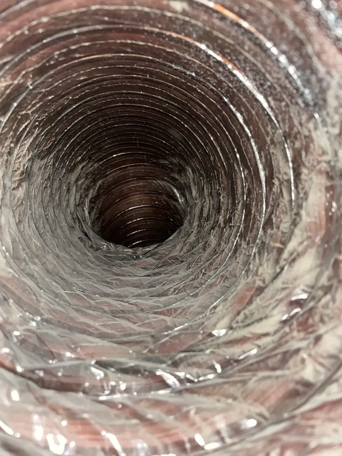 Dust clinging to the spiral ribs of a duct run