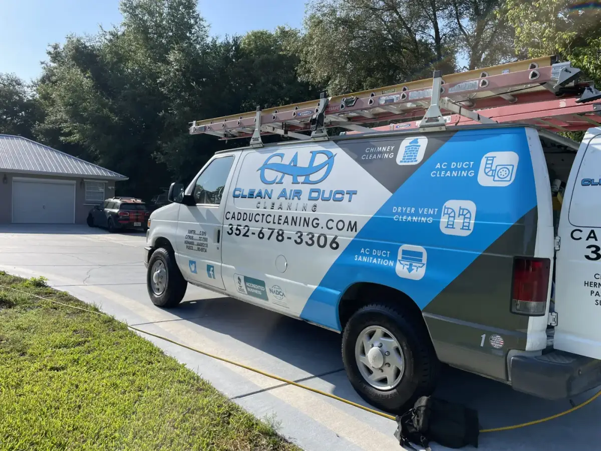 A Clean Air Duct Cleaning van parked on a driveway beside a green lawn