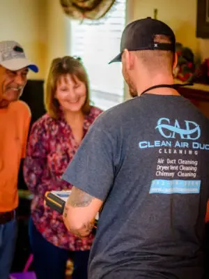 A Clean Air Duct Cleaning technician talking with customers at their Central Florida home