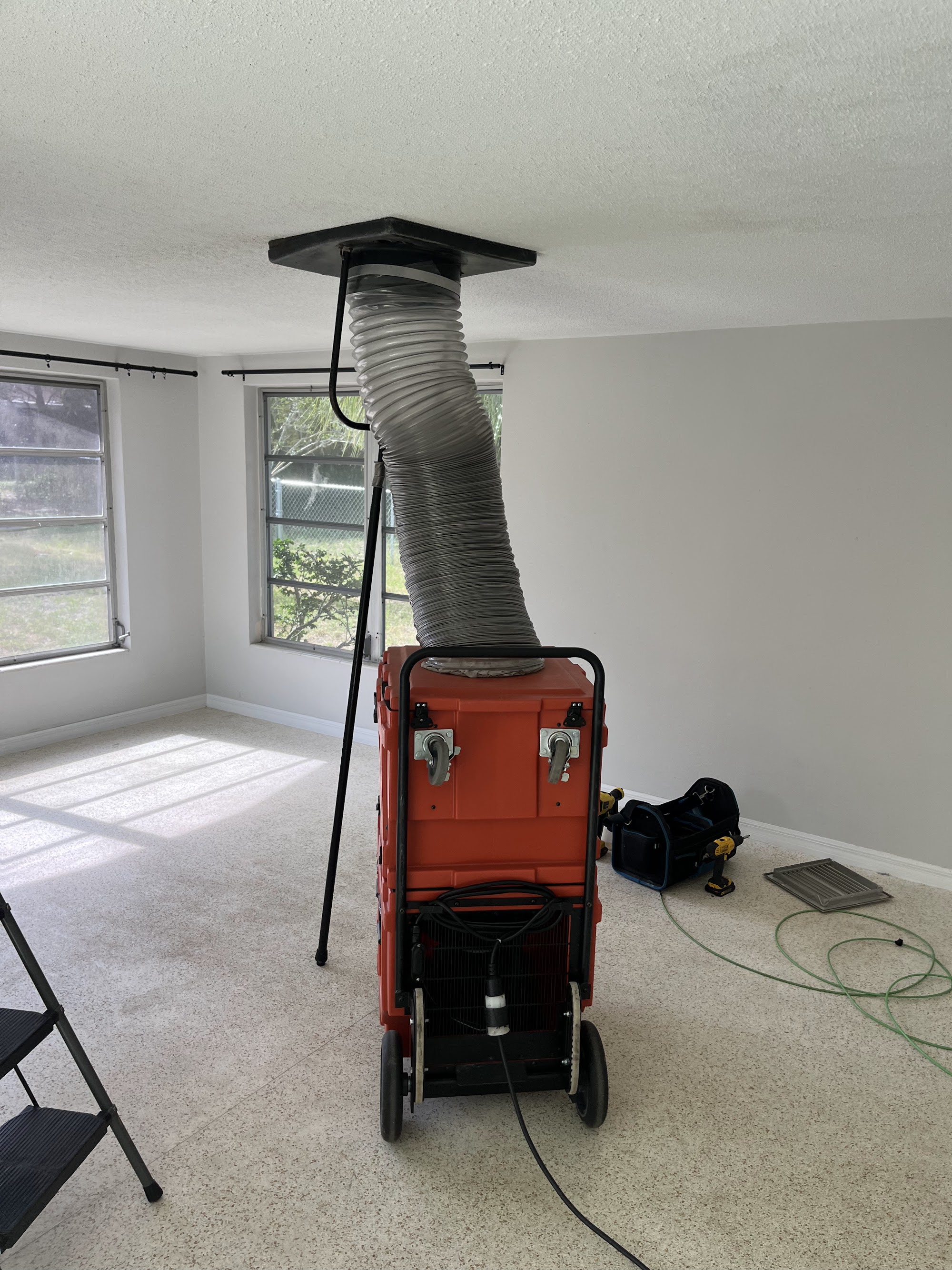 A negative-air machine connected to the duct system, putting the whole system under vacuum during cleaning